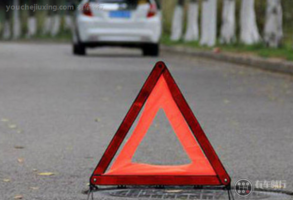 开启危险报警闪光灯并在车后50米至100米处设置警告标志